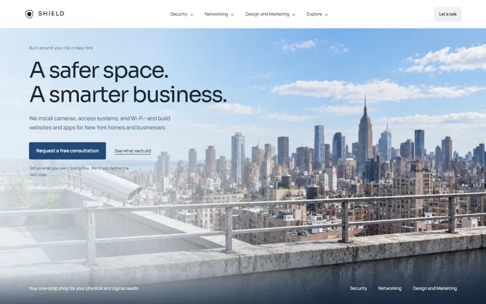 The Shield Security Solutions home page on a laptop, with a city skyline and a consultation button.