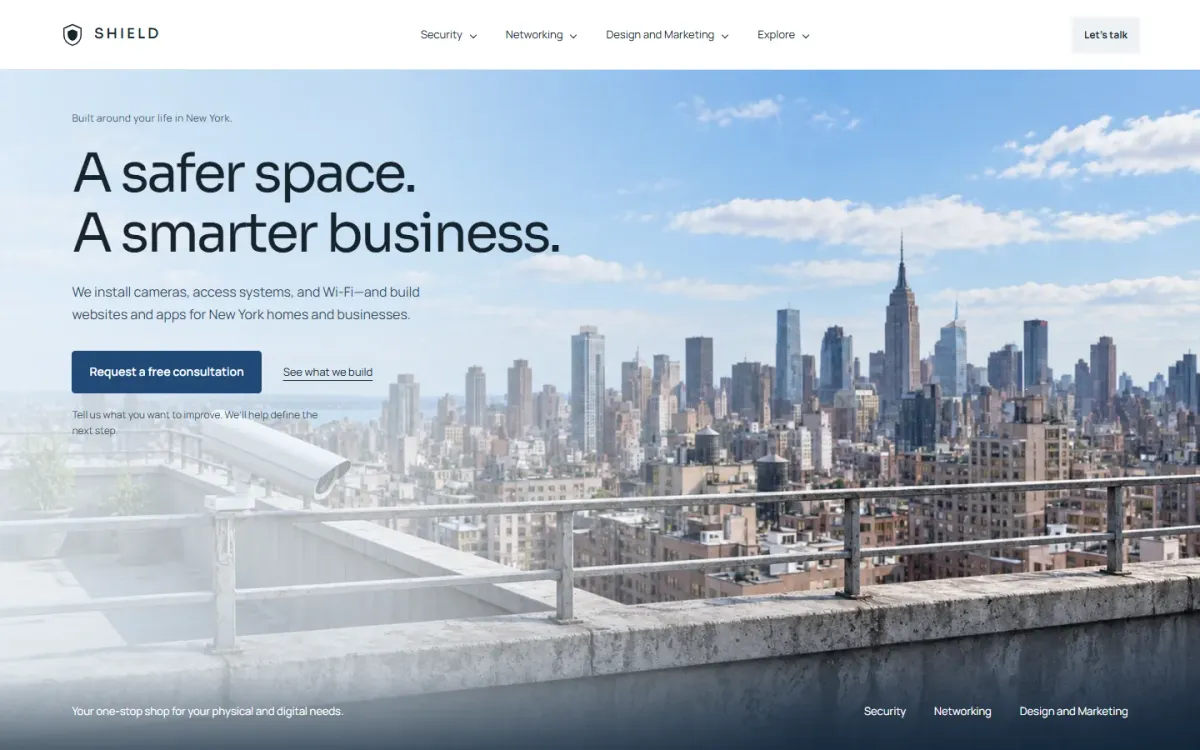 The Shield Security Solutions home page on a laptop, with a city skyline and a consultation button.